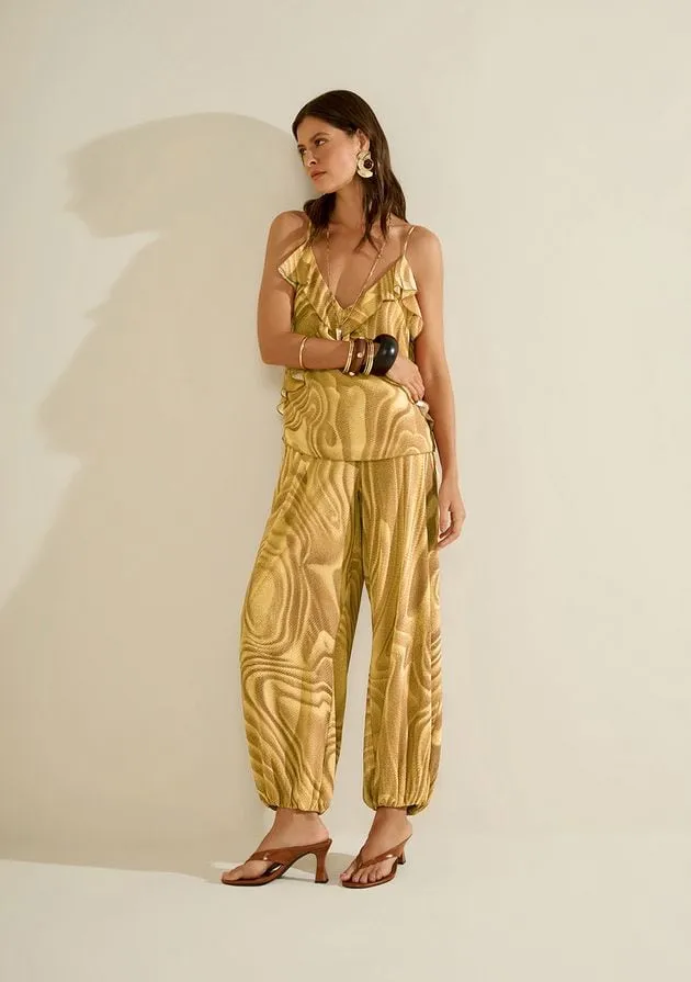 Modelo com calça de estampa marmorizada dourada