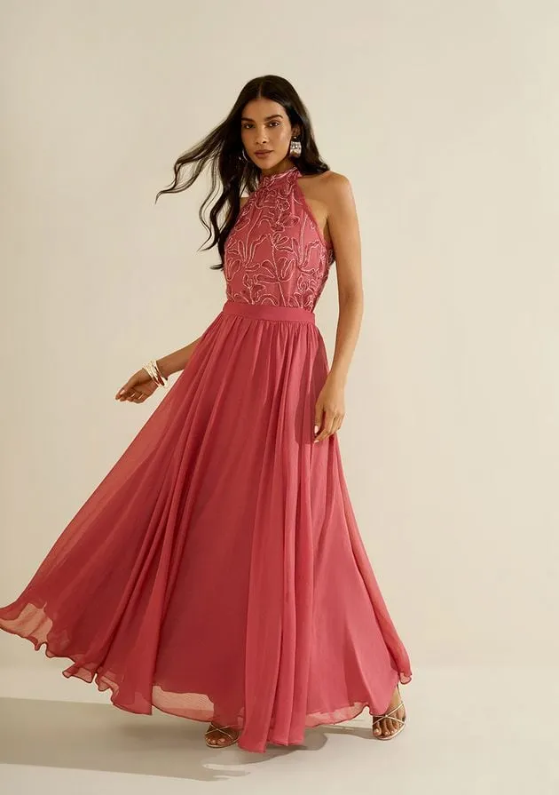 Modelo com vestido longo coral de saia fluida